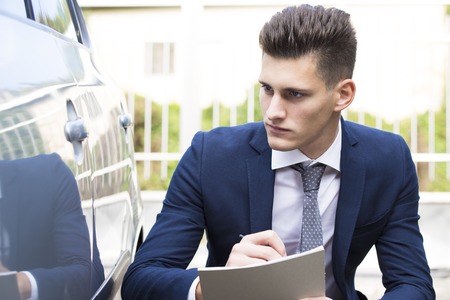 beautiful young insurance agent watching car damagedの写真素材