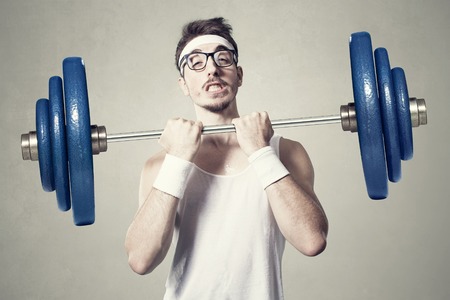 young nerd try to lift weights.の写真素材