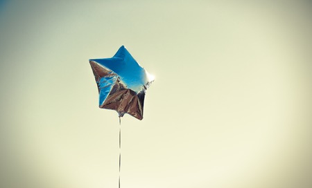 Silver star balloon on sky with color filtersの写真素材