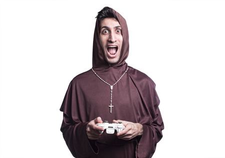 young friar playing with console joystick on grunge background
