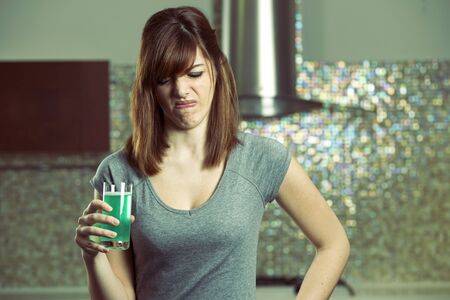young woman don't want drink disgusting green diet drink