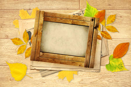 Grunge background with wooden frame and autumn leavesの写真素材