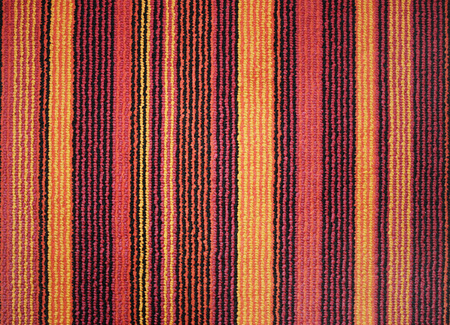 Texture of textile rug with striped pattern of red, yellow and brown colorsの写真素材