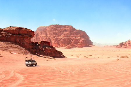 safari in Wadi Rum desert, Jordan. Tourists in the car ride on off-road on sand among the beautiful rocksの写真素材