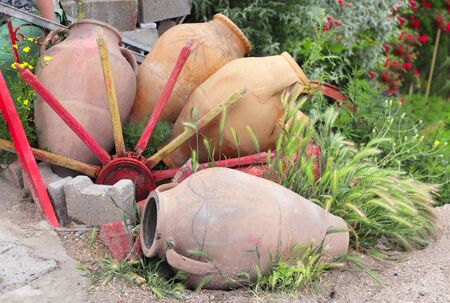 Decorative old rustic wooden colorful planks and clay jugs in ornamental garden