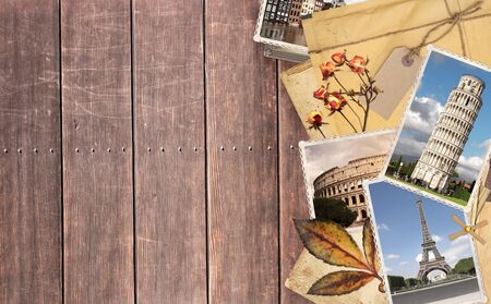 Vintage travel background with old wood planks texture, retro photos of european landmarks, envelope with label, dry rose flowers and leaf. Mock up template. Copy space for textの写真素材