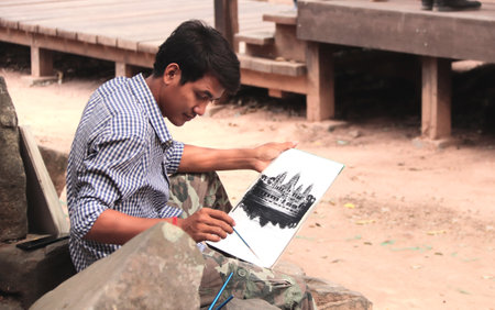 Siem Reap, Cambodia - February 10, 2020: Cambodian artist drawings picture in ruins of Angkor Watのeditorial素材