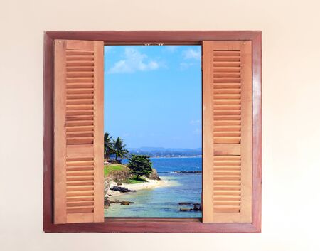 View of ocean through window with wooden shutters. Sea view room. Travel, resort , vacation and...
