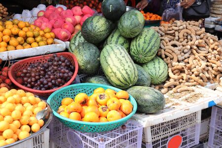 Different ripe fruits - watermelon, grapes, persimmon, tamarin, mandarin, street market, Cambodiaの写真素材