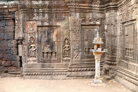 Wall carving with woman dancer apsara and traditional small spirit's house in Nokor Bachey Pagoda...
