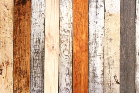 Texture of ancient wall with wooden planks of different color and cracked paint of white color