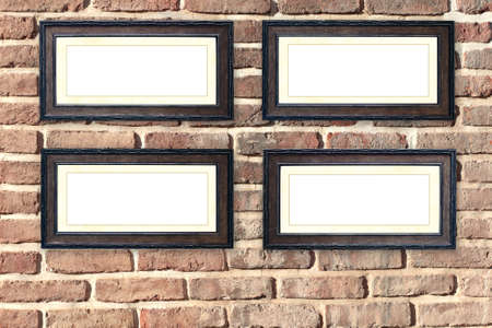 Four vintage wooden empty picture frames on old brick wall. Retro blank frame on room wall. Mock up template. Copy space for textの写真素材