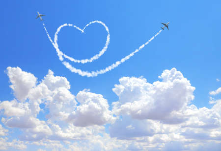 Two aircrafts draw a heart in the sky. Flight route of aircraft in shape of a heart. Love concept for traveling the worldの写真素材