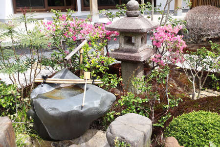Stone lantern and wash-basin in traditional japanese ornamental garden, Hasedera temple, Japan