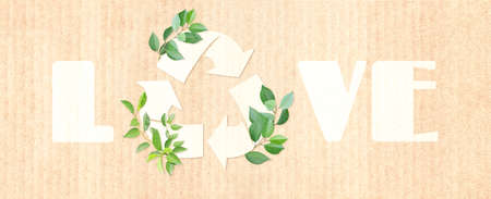 Arrows recycle symbol and green leaves on cardboard texture. Inscription Love. Banner with eco paper texture. Paper cardboard background. Recycled carton material. Ecology concept. Copy space for textの写真素材