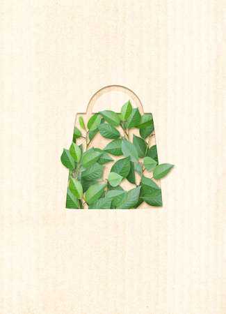 Responsible consumption. Green leaves and shopping bag in paper cut style. Eco-friendly business. Vertical banner with recycled eco paper texture. Copy space for textの写真素材