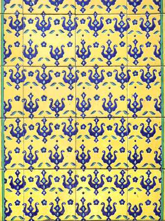 Detail of traditional persian wall with decorative ornament of blue and yellow colors on tiles, Iran