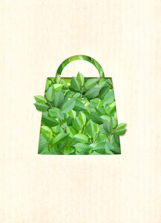 Responsible consumption. Green leaves and shopping bag in paper cut style. Eco-friendly business. Vertical banner with recycled eco paper texture. Copy space for textの写真素材