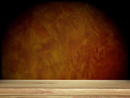 Old wooden table and stucco wall of brown color. Empty wooden table top with dark brown concrete wall background. Rustic wooden board on darken backdrop. Product display template. Copy space for textの写真素材