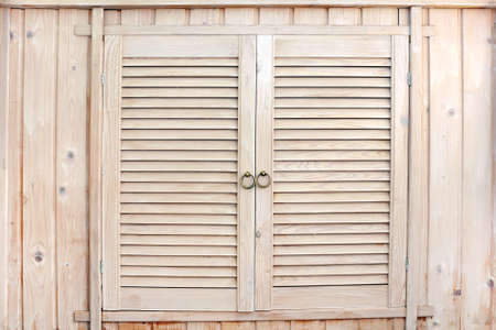 Rustic wooden cupboard. Handmade wooden locker in country style with louvered doors. Old cabinet in colonial styleの写真素材