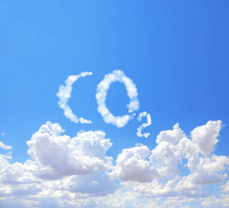 Symbol CO2 from clouds on blue sky. Carbon dioxide emission control. Pollution, global warming and climate change conceptの写真素材