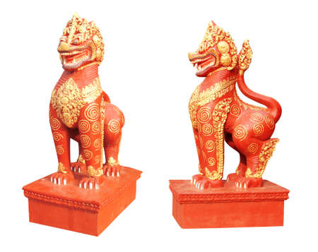 Traditional cambodian lion statue. Ancient lion sculpture of red and golden colors. Isolated on white backgroundの写真素材