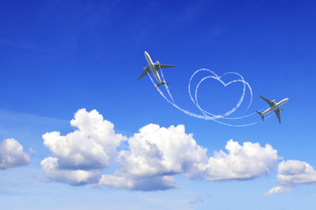 Horizontal nature background with two aircrafts draw a heart in the sky. Flight route of aircraft in shape of a heart. Love concept for traveling the worldの写真素材