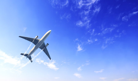 Horizontal nature background with aircraft and Jet trailing smoke in the sky. Airplane and condensation trail. Foggy trail jet and plane in blue sky with white clouds. Traveling the world conceptの写真素材