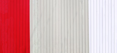 Wave Sheets fence of red, beige and white colors. Horizontal background with galvanized iron sheets of different color. Colored corrugated metal roofing sheetの写真素材