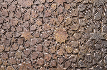Detail of wooden door with traditional islamic ornament. Wood window shutter with antique iranian geometric pattern. Oriental ornament with artistic carving for woodの写真素材