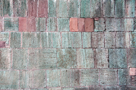 Texture of wall with stone blocks of red, green and gray colors. Horizontal background with decorative stone wall textureの写真素材