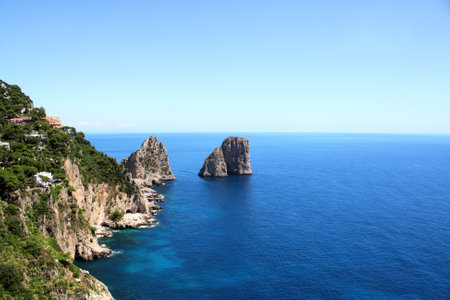 Top view on famous Faraglioni Rocks, Capri Island, Italy. Aerial view of beautiful landscape with azure sea, Capri island coastline and Faraglioni cliffsの写真素材