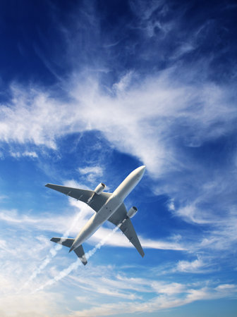 Vertical nature background with aircraft and Jet trailing smoke in sunset sky. Airplane and condensation trail. Foggy trail jet and plane in sunrise sky with clouds. Traveling the world conceptの写真素材