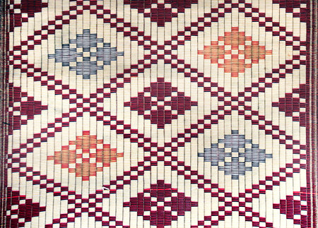Sisal mat with traditional asian geometric patterns. Jute handmade rug with ornament of red, blue, white  and yellow colorの写真素材