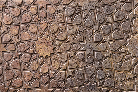 Detail of wooden door with traditional islamic ornament. Wood window shutter with antique iranian geometric pattern. Oriental ornament with artistic carving for woodの写真素材