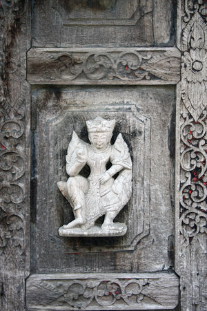 Detail of ancient wooden carved wall ornament with a mythical hero, Shwenandaw monastery (Golden Palace Monastery), Mandalay region, Myanmar, Indochinaの写真素材