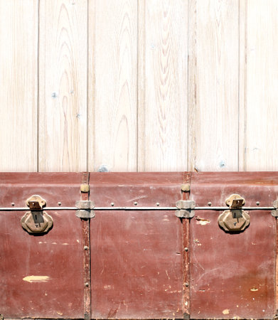 Retro background with red vintage chest upholstered in leather with brass snaps and wall with wooden boards. Product display template. Shabby chic style backdrop. Mock up template. Copy space for textの写真素材
