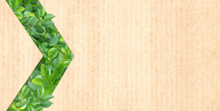 Green leaves and arrow symbol on recycled cardboard texture . Horizontal banner with eco paper texture. Paper background. Recycled carton material. Ecology and zero waste concept. Copy space for textの写真素材