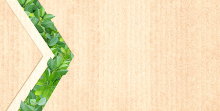Green leaves and arrow symbol on recycled cardboard texture . Horizontal banner with eco paper texture. Paper background. Recycled carton material. Ecology and zero waste concept. Copy space for textの写真素材