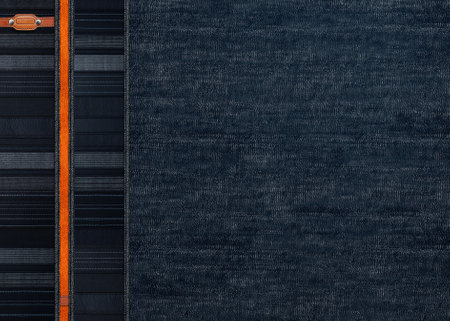 Black denim background with striped borders and small leather label. Dark grey and orange color denim jeans fabric texture. Mock up template. Copy space for textの写真素材