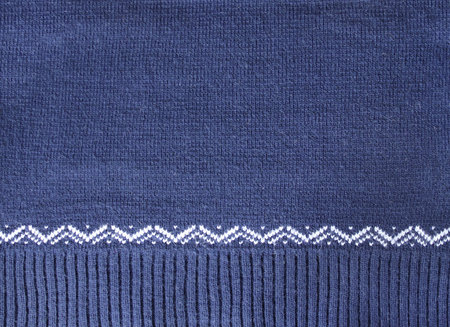 Wool sweater texture of dark blue color with white border. Natural knitted wool indigo color material with white ornament. Horizontal or vertical background with knitted fabric textureの写真素材