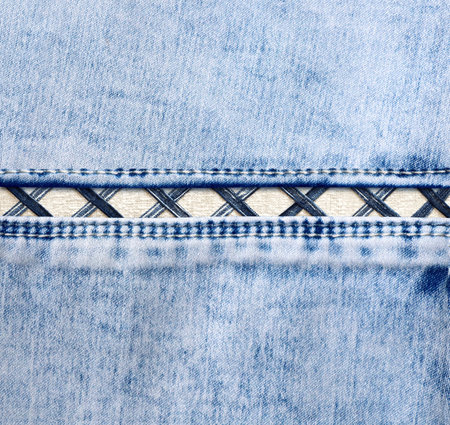 Blue denim background with a seam. Light blue color denim jeans fabric texture. Copy space for textの写真素材