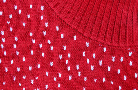 Wool sweater texture of red color with white dotted. Natural knitted wool dark red color material with white ornament. Horizontal or vertical background with knitted fabric textureの写真素材