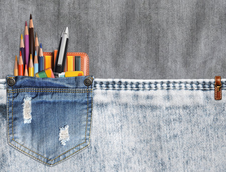 Back to school. Pencils and pens in denim pocket. Jeans pocket with office supplies. Education concept. Horizontal background with linen and denim texture. Mock up template. Copy space for textの写真素材