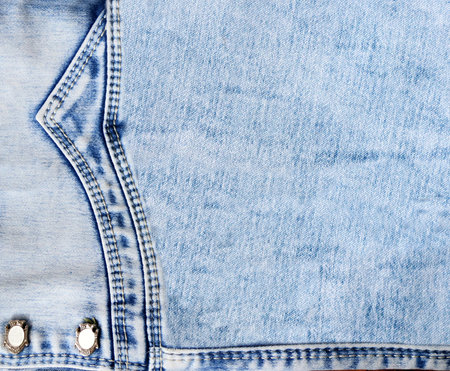 Blue denim background with a seam. Light blue color denim jeans fabric texture. Copy space for textの写真素材
