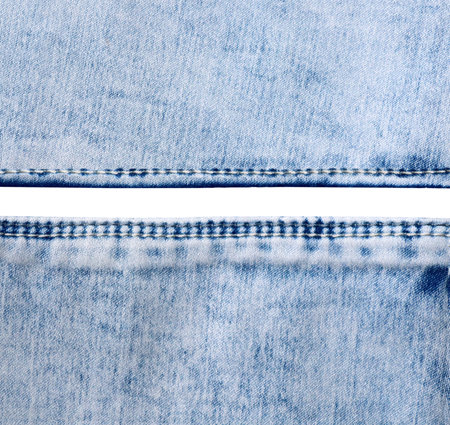 Blue denim borders with a seam. Light blue color denim jeans fabric texture. Isolated on white background. Copy space for textの写真素材