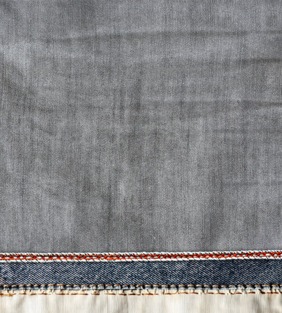 Grey and light grey denim background with a red seam. Light gray color denim jeans fabric texture with decorative border. Copy space for textの写真素材