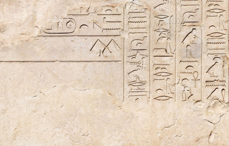 Horizontal background with ancient Egyptian hieroglyphs on stone wall, Egypt, Africa. Backdrop with sandstone carving with hieroglyph. Mock up template. Copy space for textの写真素材