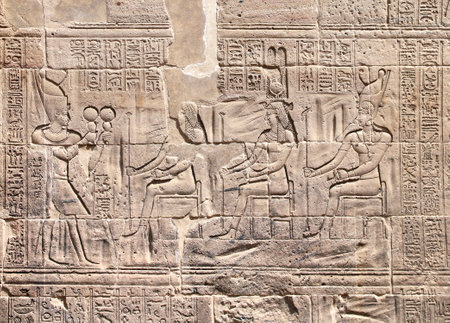 Ancient Egyptian bas-relief on stone wall. Figure of the pharaoh making ritual offerings to the goddess Isis. Temple of Isis on Agilkia Island (Philae), reservoir of Aswan Low Dam, Egyptの写真素材