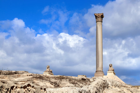 Famous landmark - Serapeum of Alexandria. Two Sphinx and Pompey's Pillar in Alexandria, Egypt, North Africa. Roman temple Serapeum with Pompey's pillar and sphinxesの写真素材